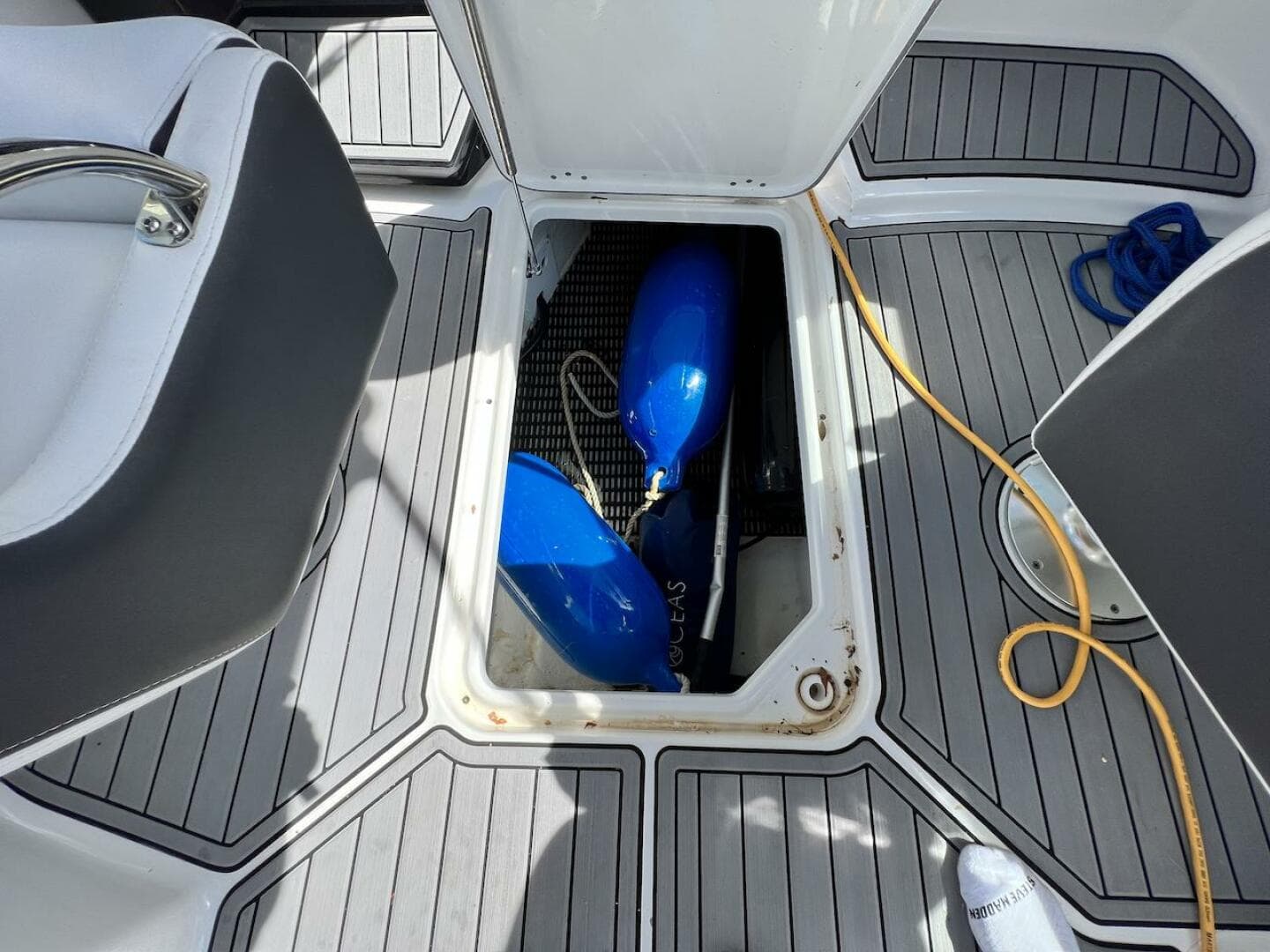 Storage compartment on a 2022 Monterey M-45 boat with blue fenders and yellow cord.