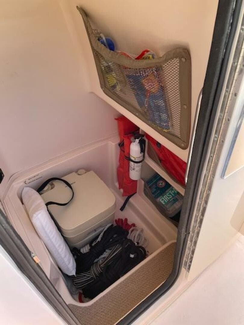 2014 Grady-White Fisherman 257 storage compartment with safety equipment and supplies.