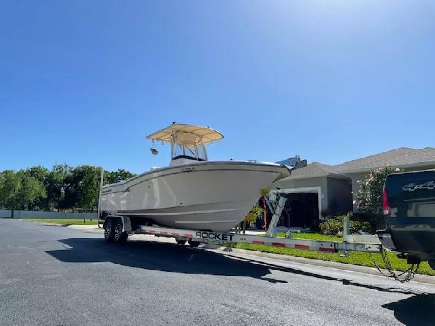 2014 Grady-White Fisherman 257 boat on a trailer in a residential area.