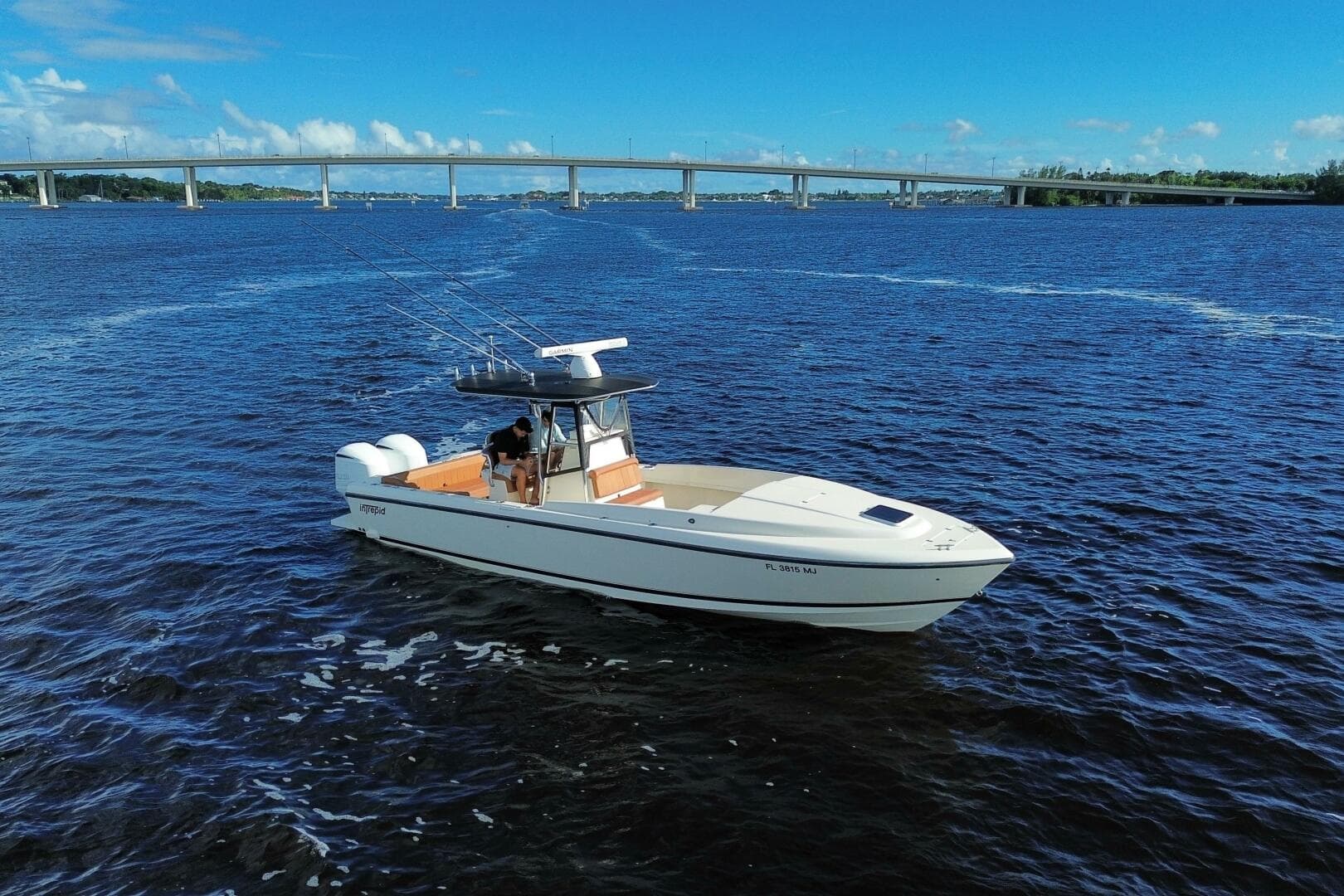 2004 Intrepid 32 Cuddy boat on open water with bridge in background.