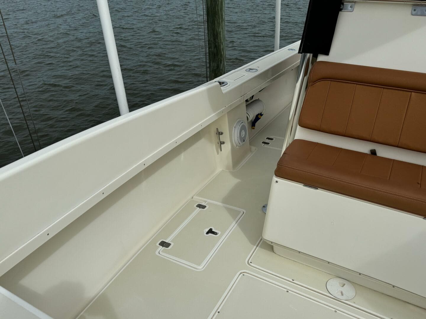 2004 Intrepid 32 Cuddy boat interior with tan seating and storage compartments.