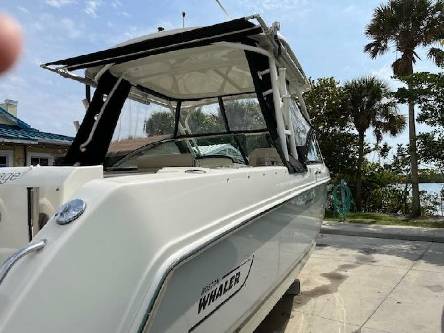 2018 Boston Whaler 270 Vantage boat docked near palm trees.