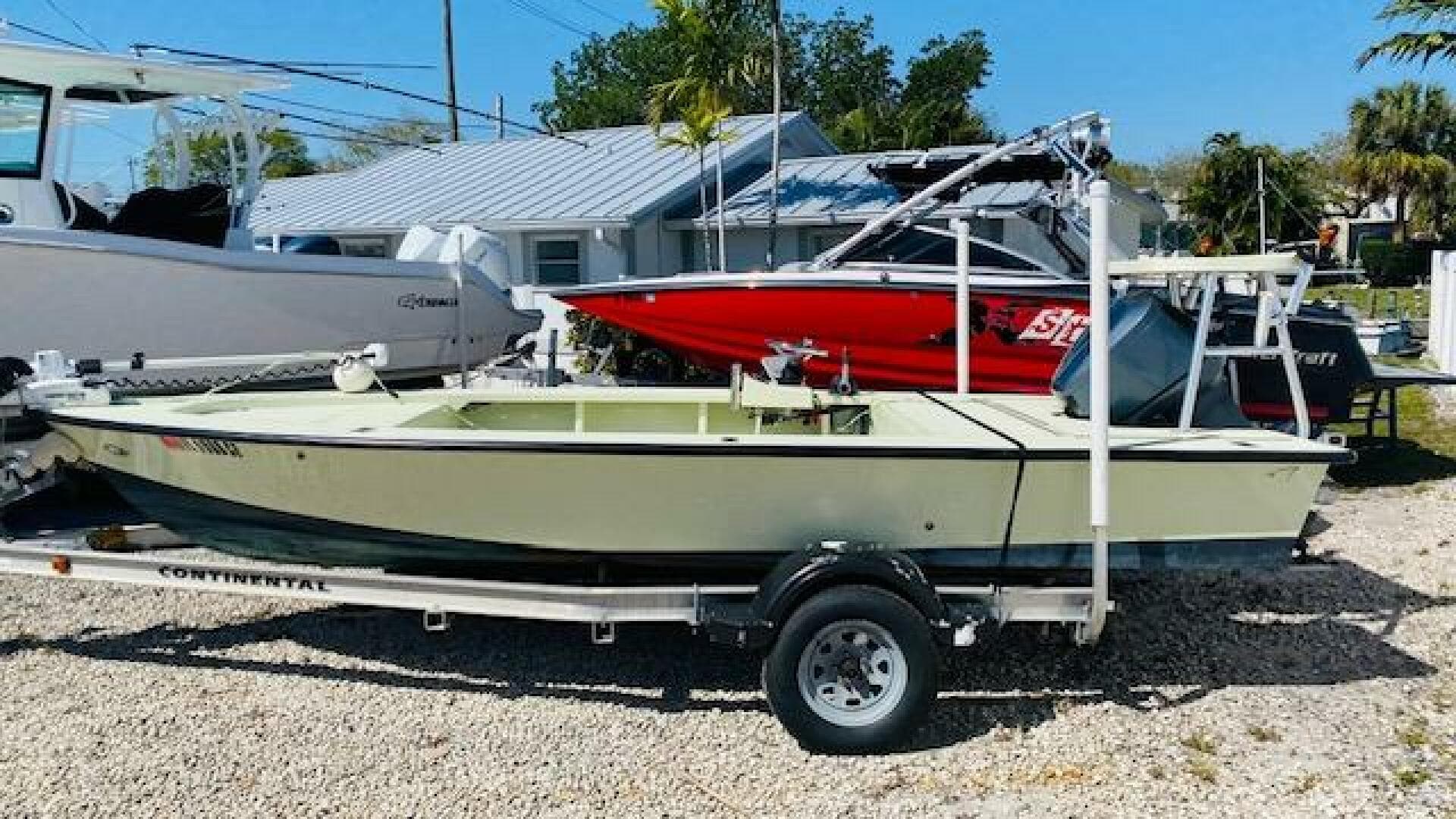 1983 Maverick 18 Flats Boat on trailer, parked outdoors near other boats.