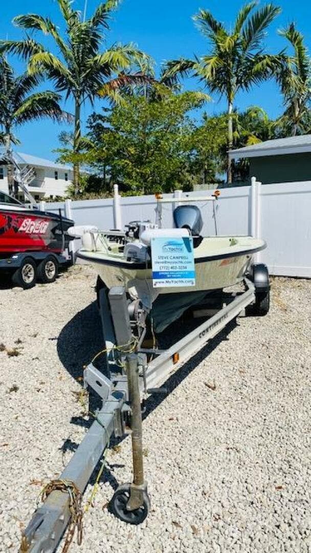 1983 Maverick 18 Flats Boat on trailer, parked outdoors with palm trees in the background.