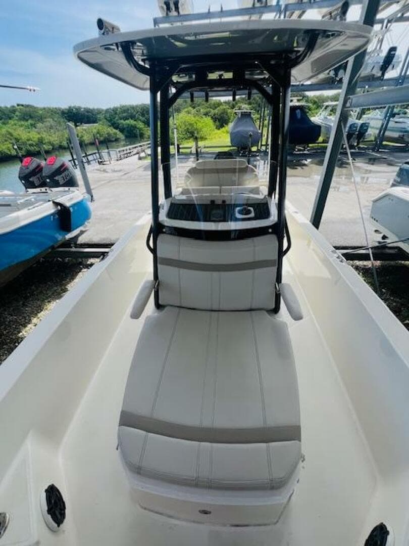 2023 Boston Whaler 250 Dauntless boat interior with seating and console, docked outdoors.
