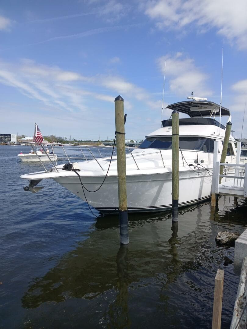 1997 Sea Ray 550 Sedan Bridge yacht docked at marina under blue sky.