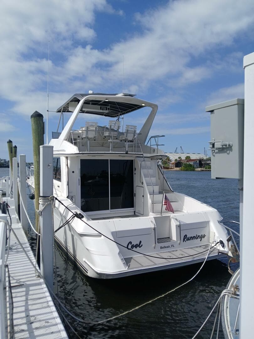 1997 Sea Ray 550 Sedan Bridge yacht docked at marina under blue sky.