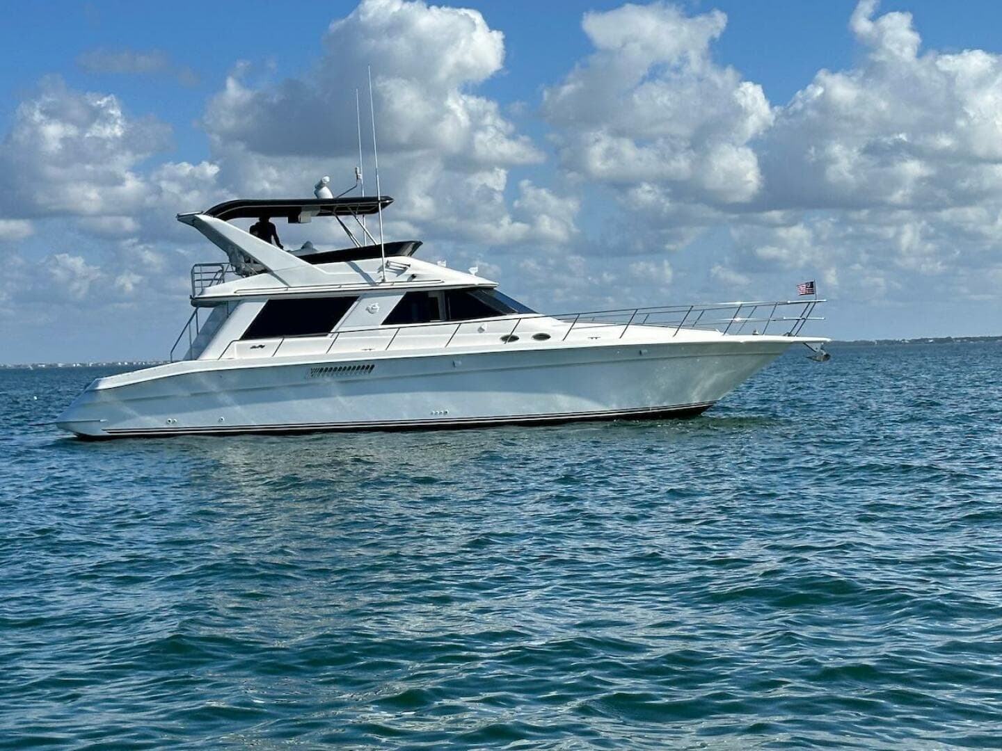 1997 Sea Ray 550 Sedan Bridge yacht cruising on open water.