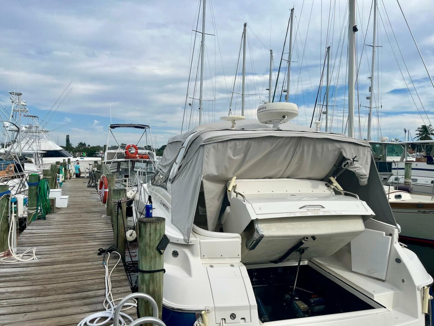 2003 Regal Commodore 3860 yacht docked at a marina with sailboats in the background.