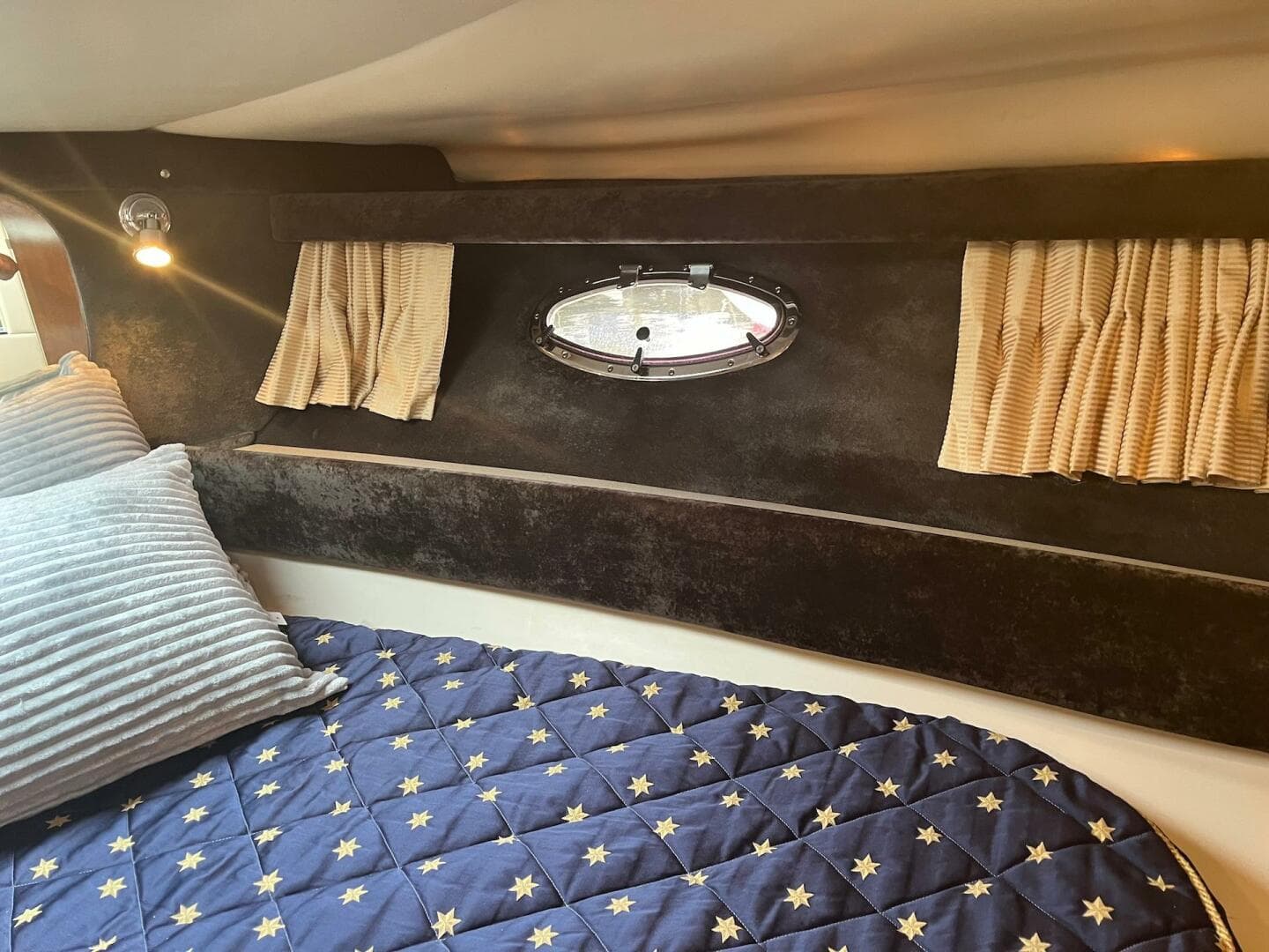 Interior cabin of 2003 Regal Commodore 3860 with bed, pillows, and porthole window.