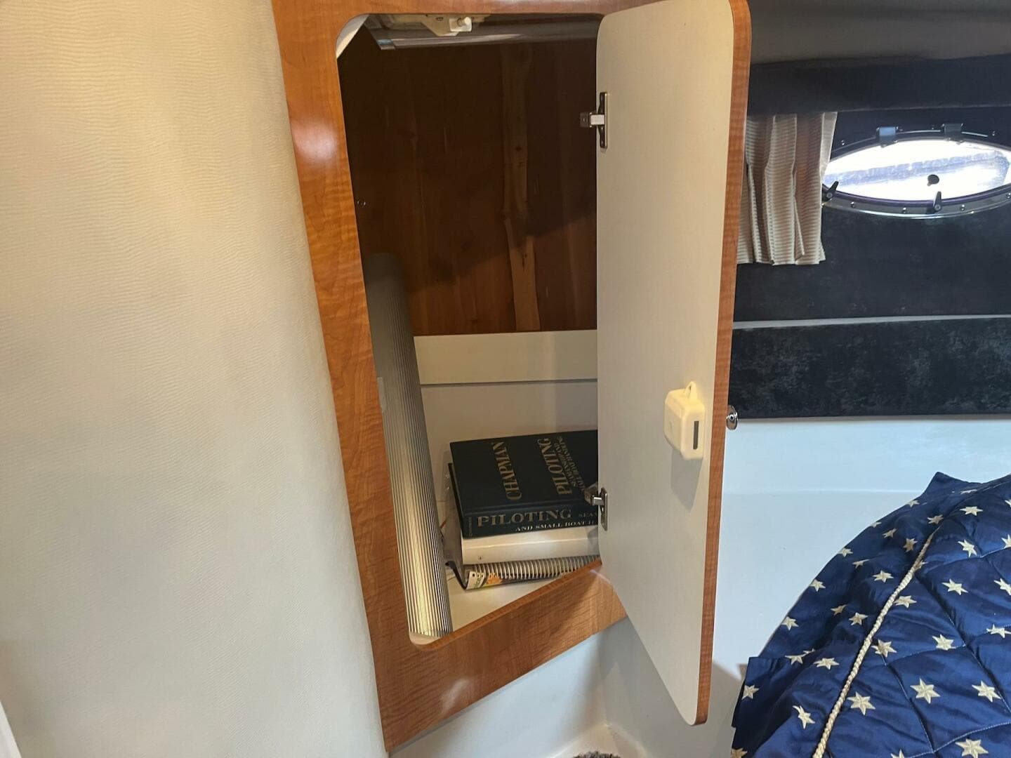 Open cabinet in 2003 Regal Commodore 3860 boat with books inside.