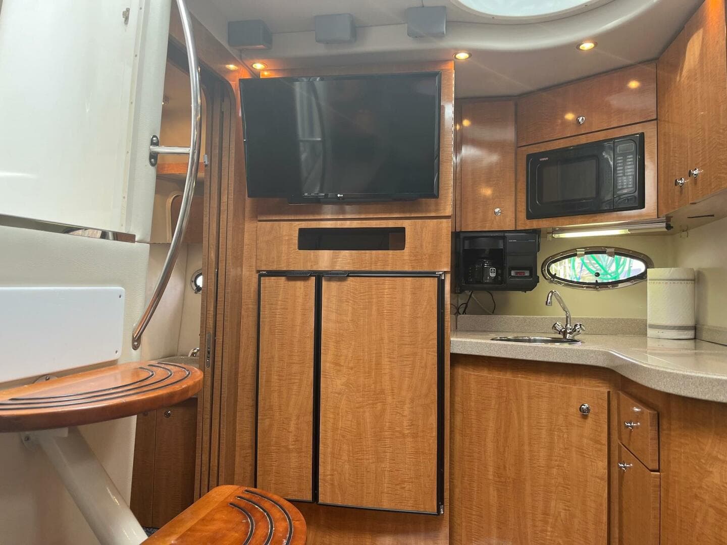 Interior of 2003 Regal Commodore 3860 yacht with kitchen, TV, and wooden cabinetry.