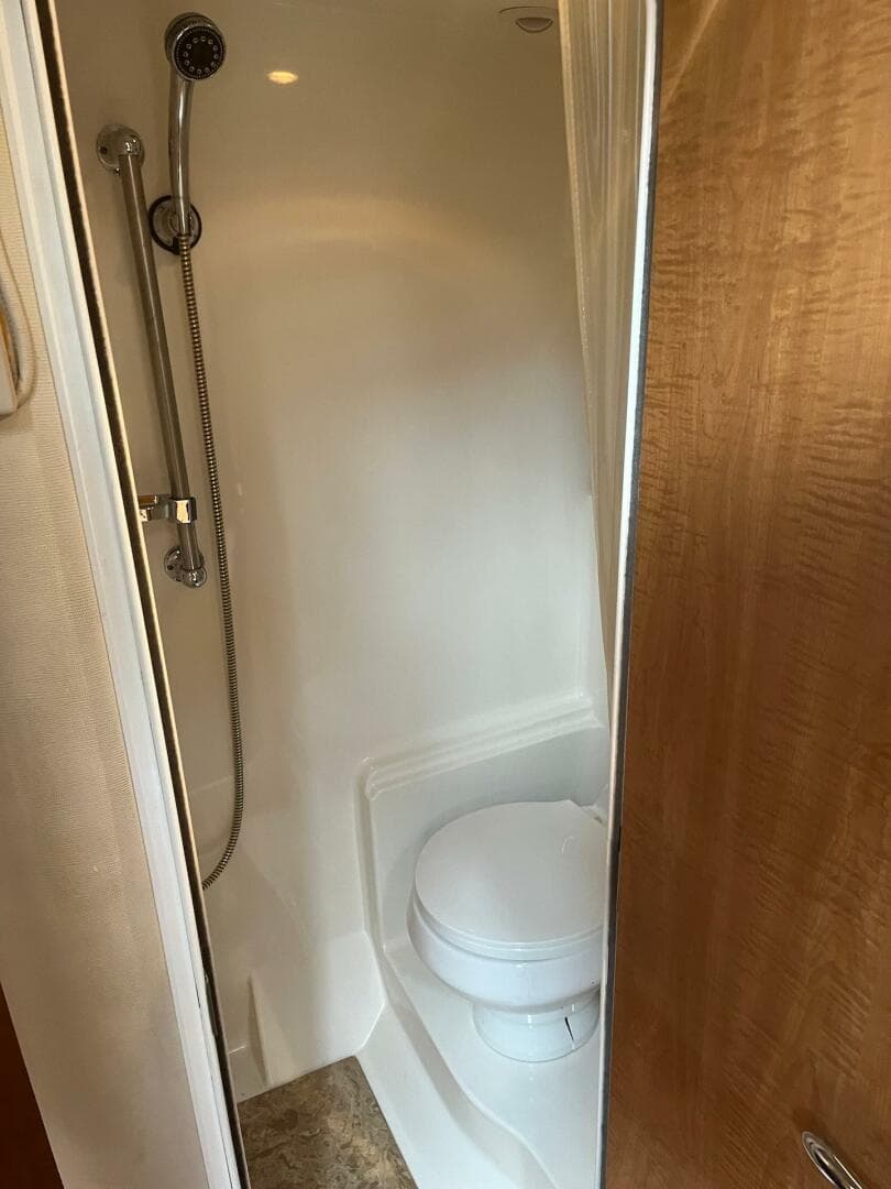Compact bathroom with shower and toilet in 2003 Regal Commodore 3860 yacht.