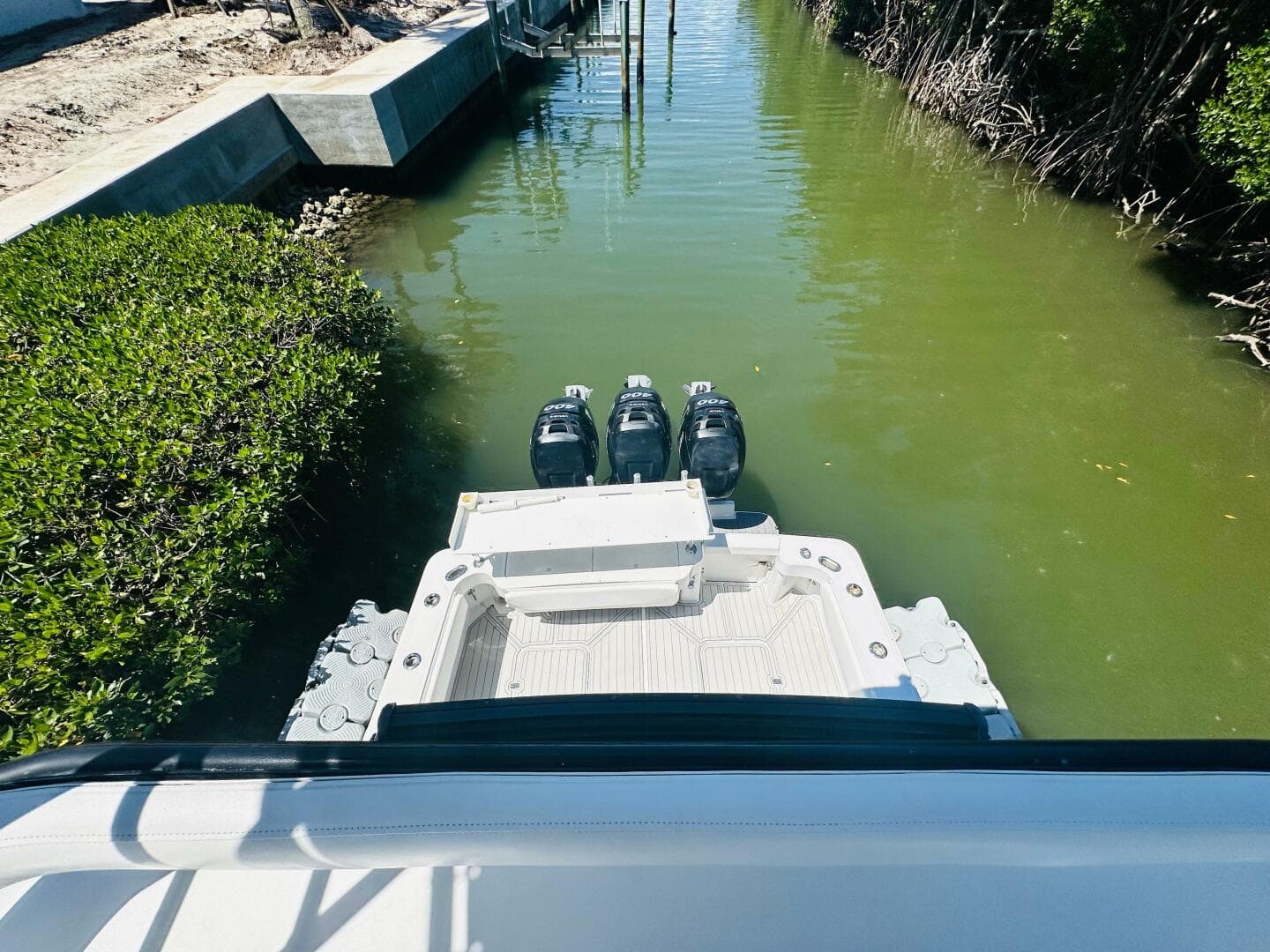 2000 Luhrs Tournament 320 Open boat with triple outboard motors in a narrow waterway.