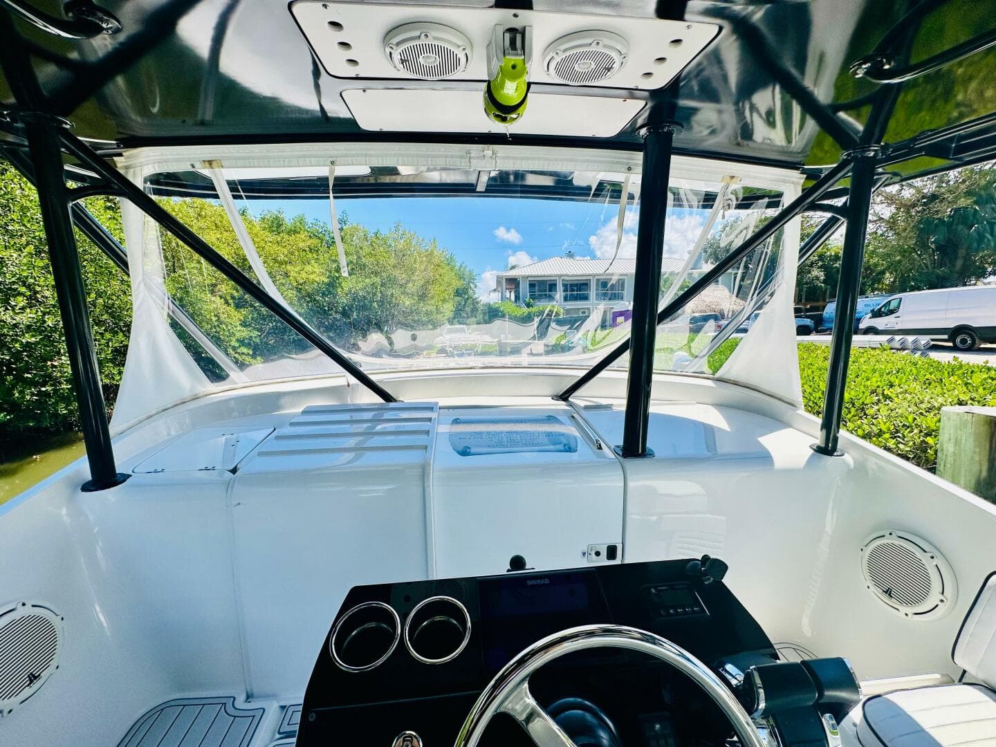 2000 Luhrs Tournament 320 Open boat helm with clear canopy and scenic view.