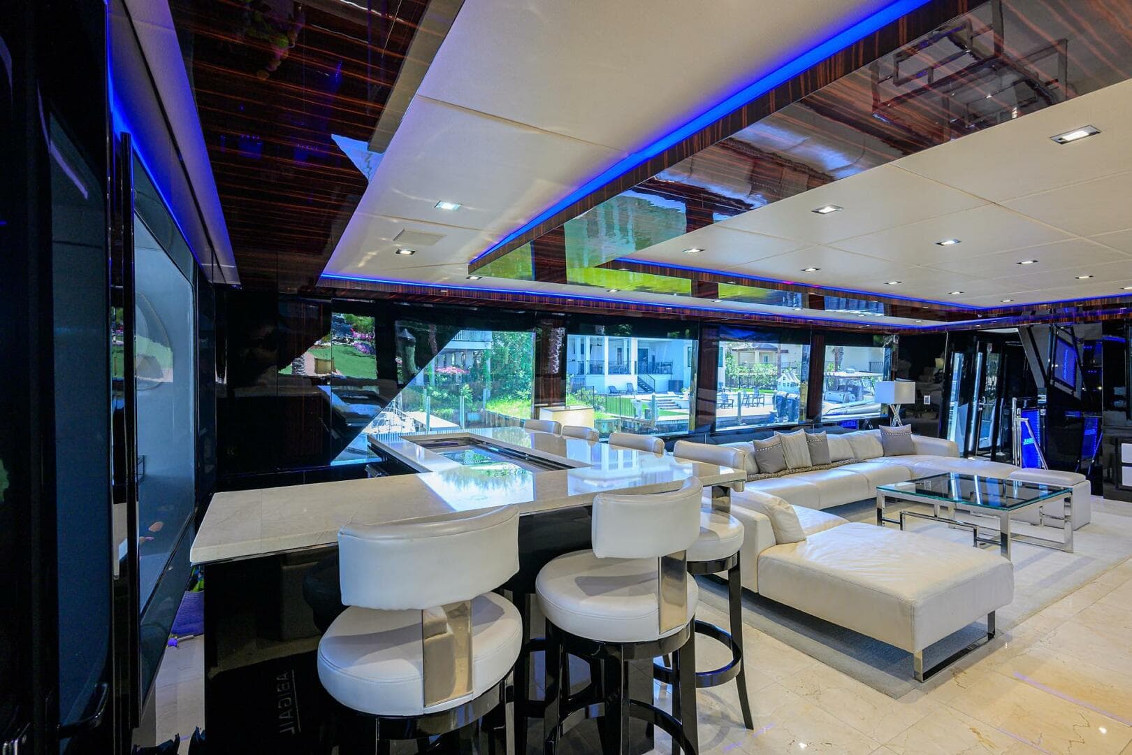 Luxurious interior of 1997 Broward 108 Raised Pilothouse yacht with modern seating and ambient lighting.