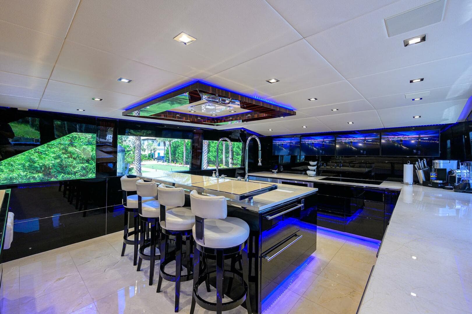 Luxurious interior of 1997 Broward 108 Raised Pilothouse yacht with modern kitchen and bar stools.