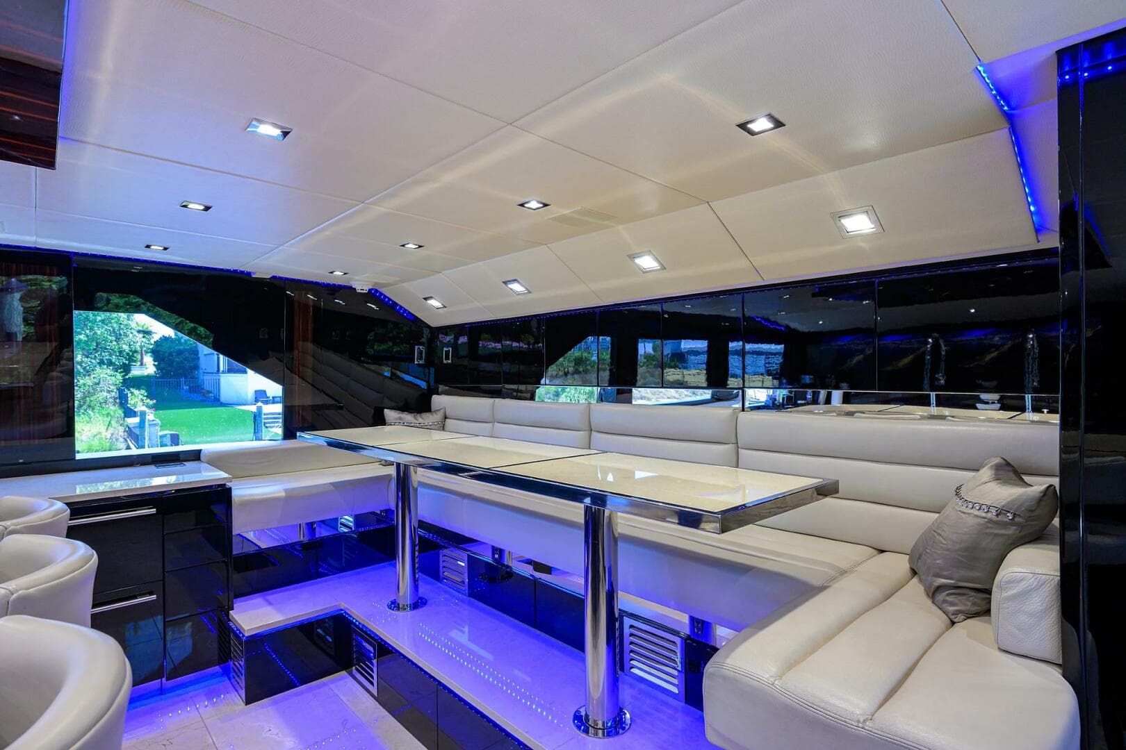 Luxurious interior of 1997 Broward 108 Raised Pilothouse yacht with modern seating and ambient lighting.