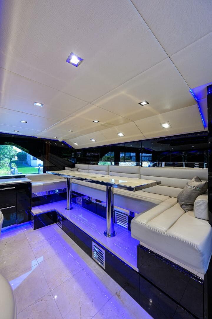Luxurious interior of 1997 Broward 108 Raised Pilothouse yacht with modern seating and blue LED lighting.