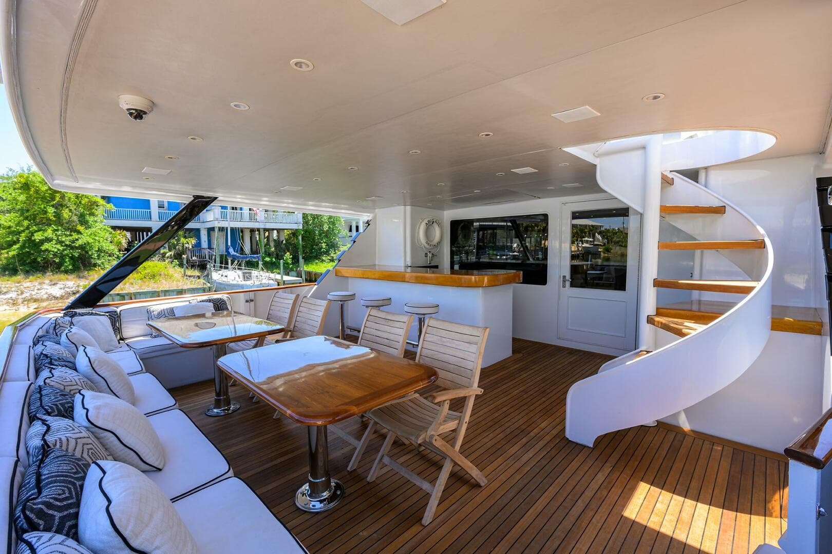 Luxurious deck of 1997 Broward 108 Raised Pilothouse yacht with seating and spiral staircase.