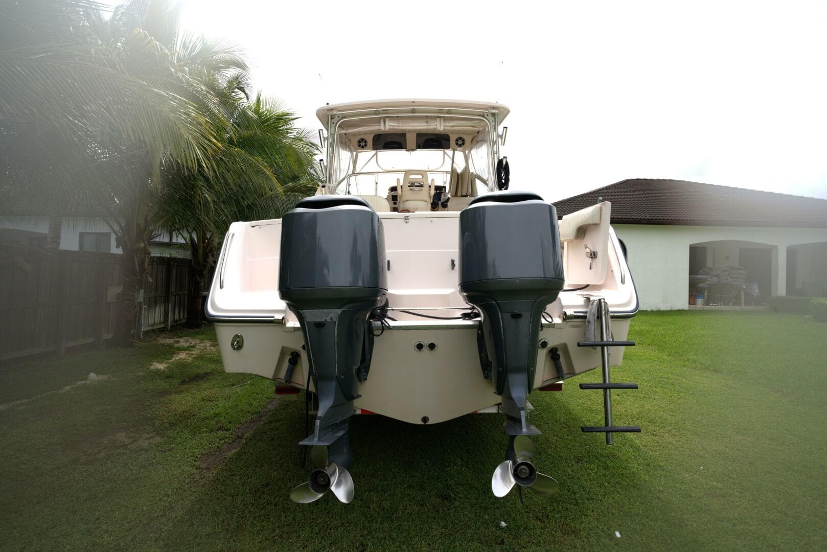 2007 Grady-White Express 330 boat with dual outboard motors on grassy lawn.