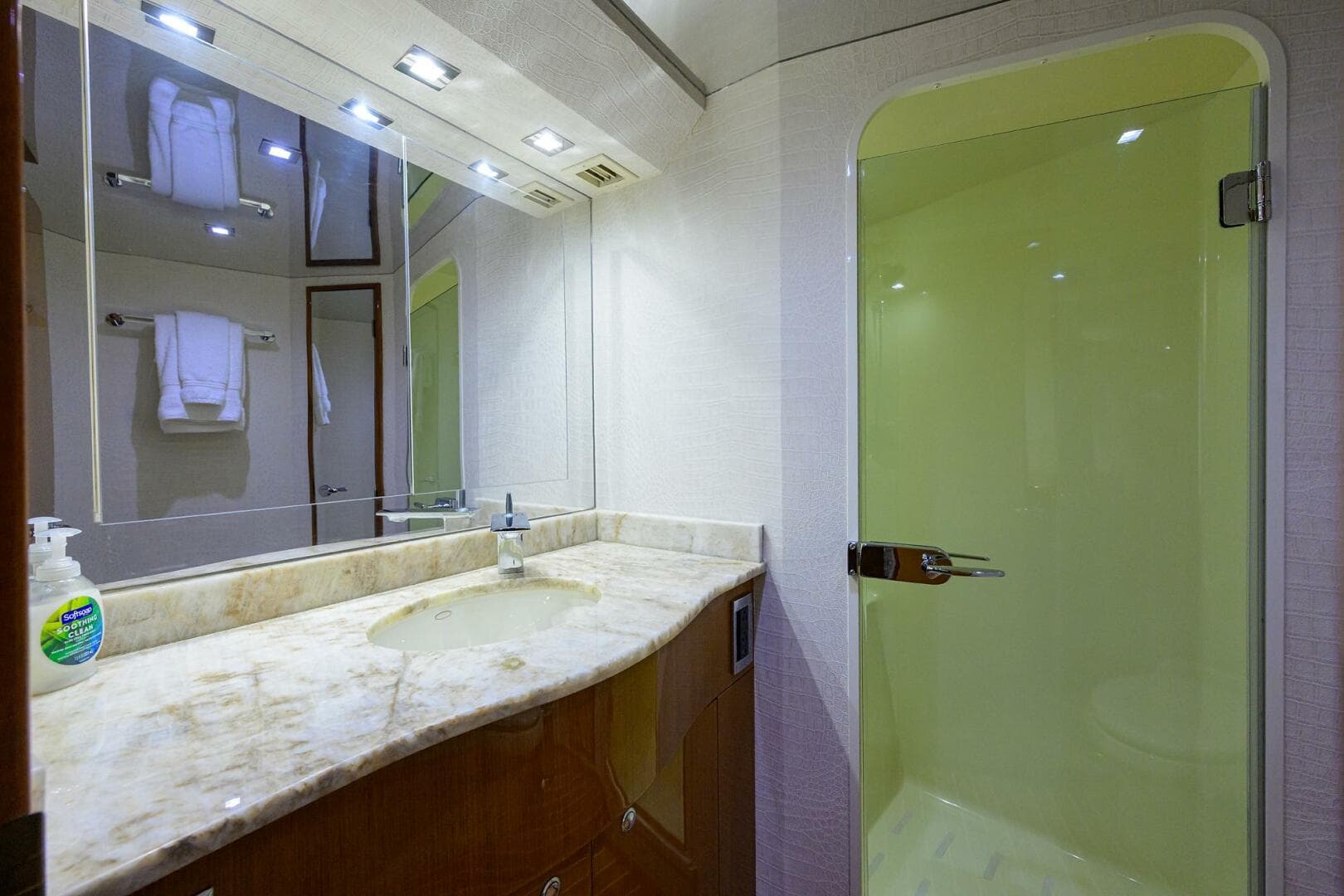 Luxurious bathroom in 2004 Viking 65 Enclosed Bridge yacht with marble countertop and glass shower.