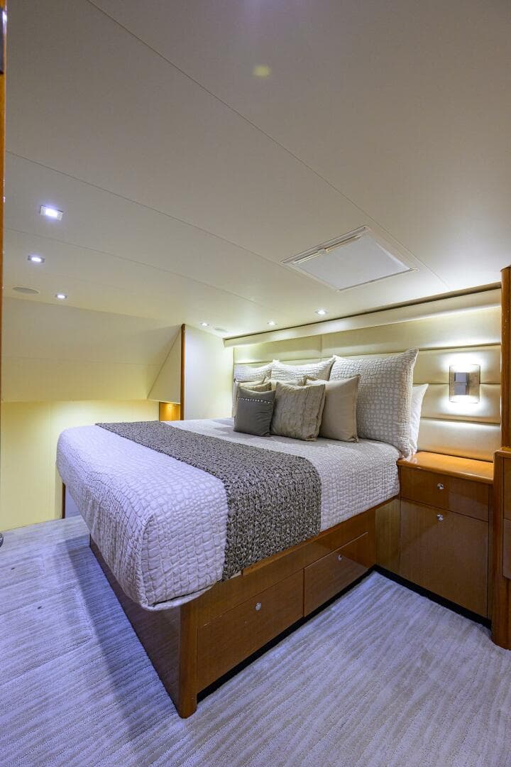 Luxurious bedroom interior of 2004 Viking 65 Enclosed Bridge yacht with modern lighting.