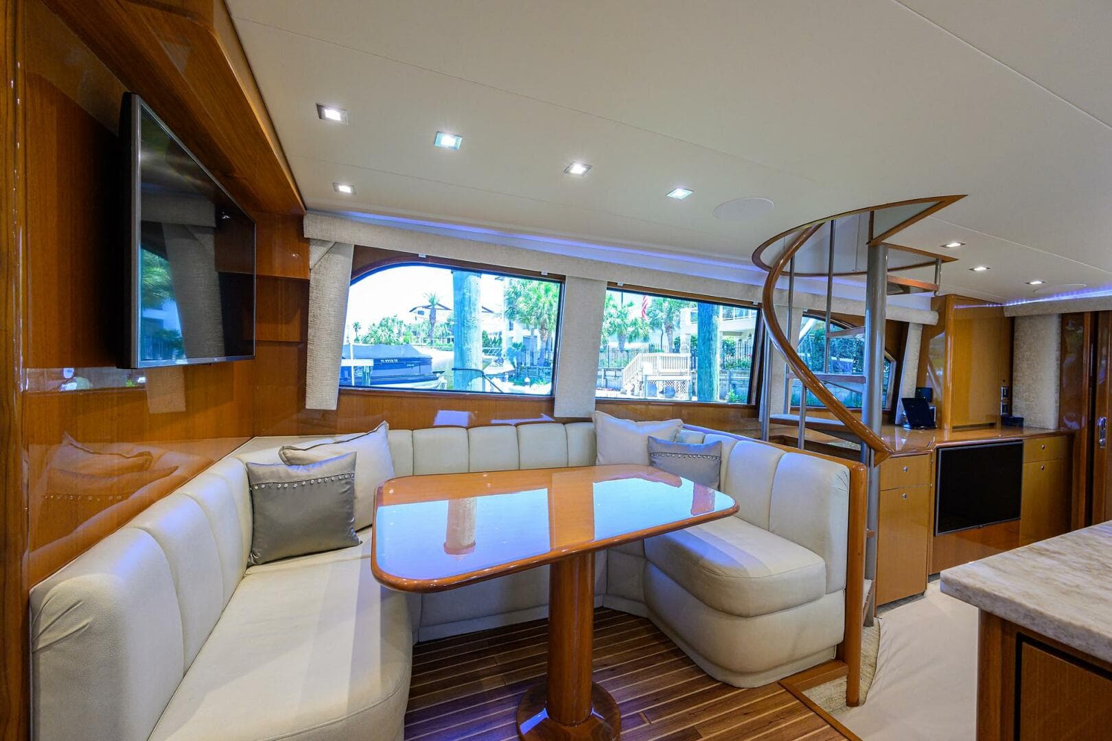 Luxurious interior of 2004 Viking 65 Enclosed Bridge yacht with dining area and spiral staircase.