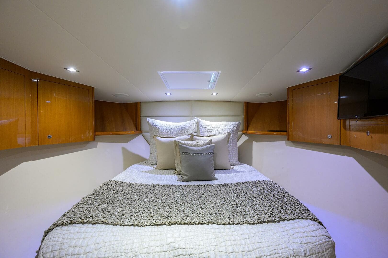 Luxurious bedroom interior of 2004 Viking 65 Enclosed Bridge yacht with cozy bedding.