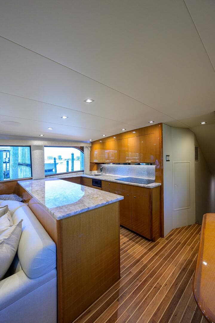 Luxurious interior of 2004 Viking 65 Enclosed Bridge yacht with modern kitchen and seating area.