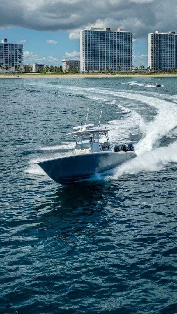 2025 Billfish 39 Center Console boat cruising near coastal skyscrapers.