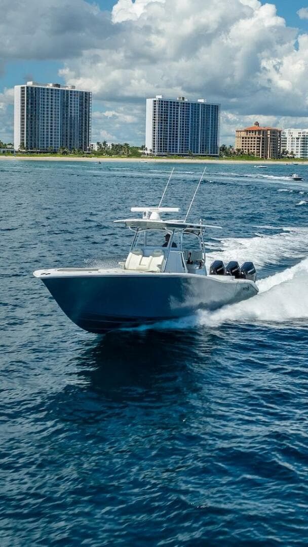 2025 Billfish 39 Center Console boat cruising near coastal skyscrapers.