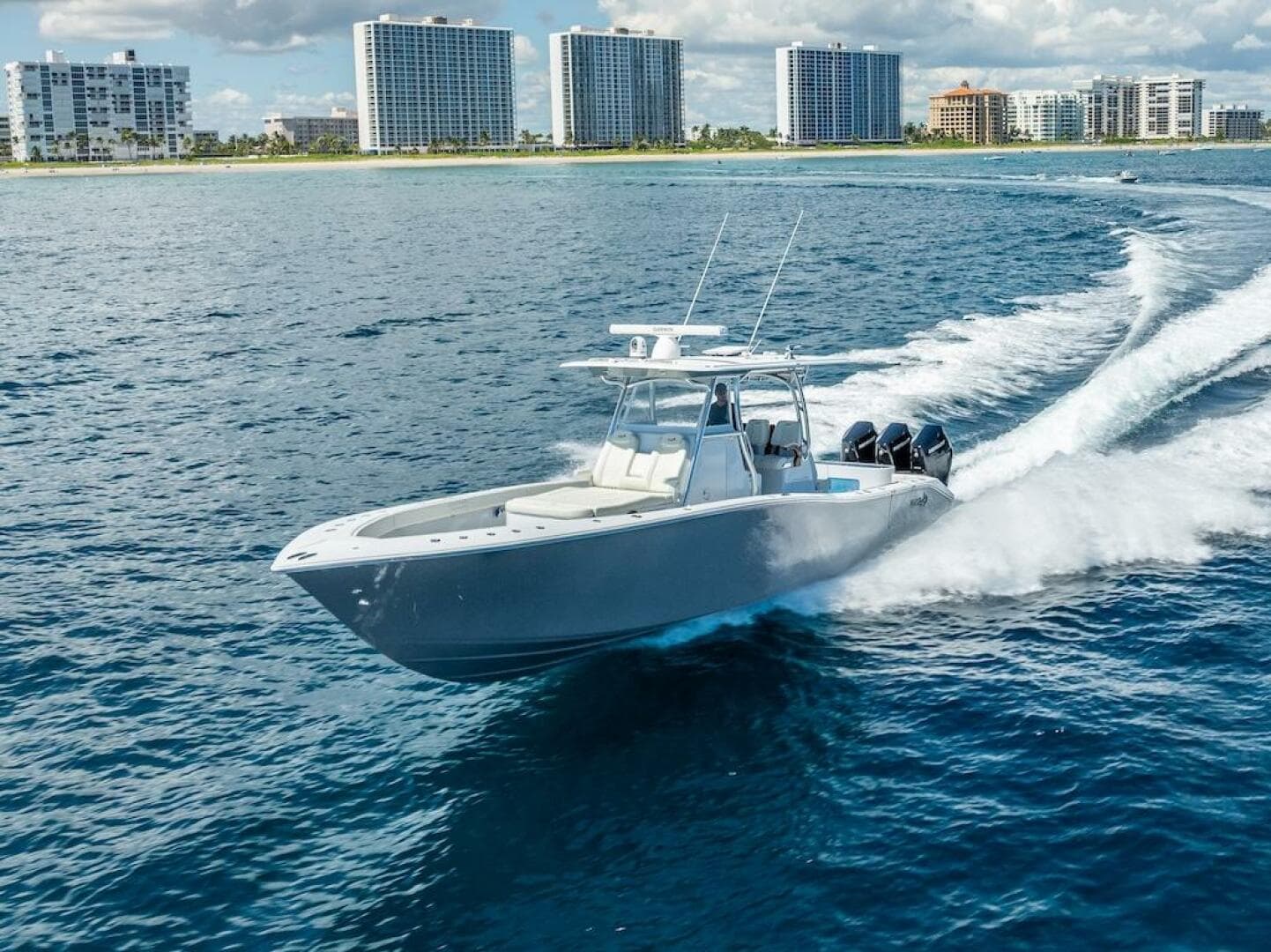 2025 Billfish 39 Center Console boat cruising near coastal city skyline.