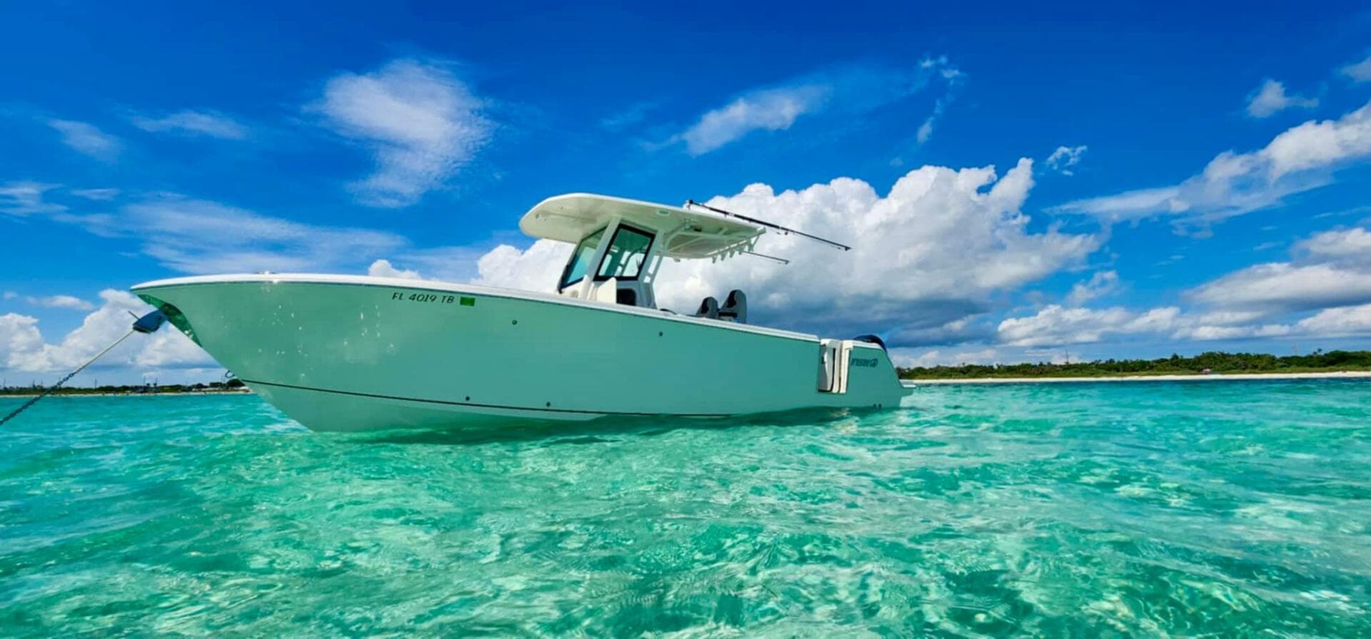 2021 Sailfish 272 CC boat on clear turquoise water under blue sky.