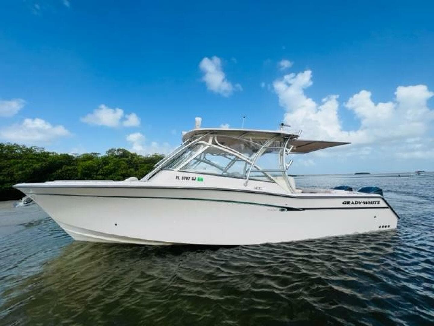 2014 Grady-White Freedom 335 boat on calm water with blue sky background.