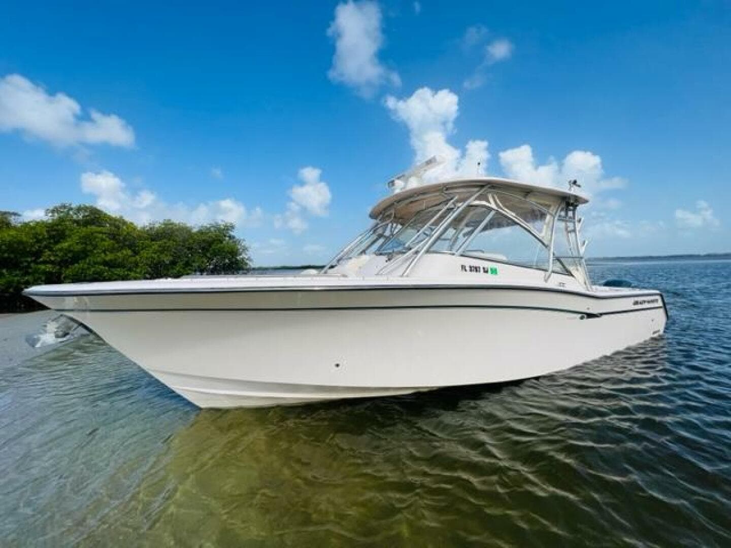 2014 Grady-White Freedom 335 boat on calm water with blue sky background.