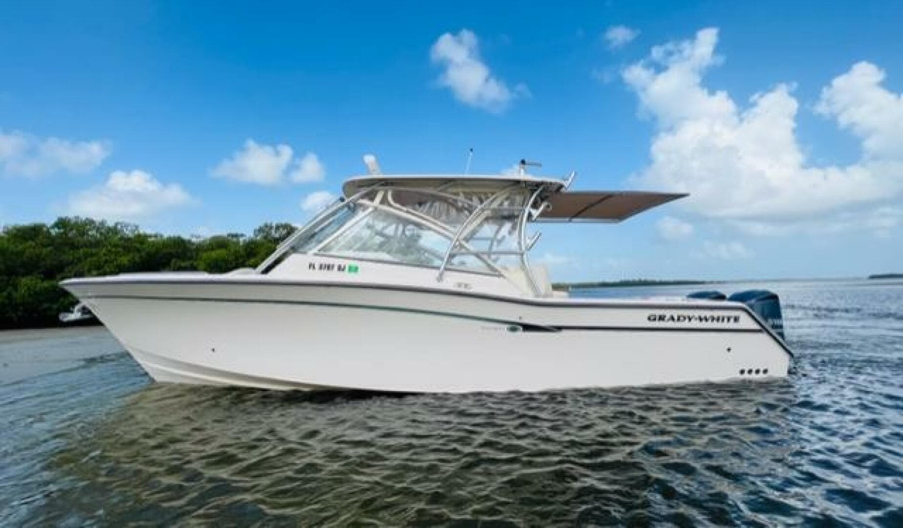 2014 Grady-White Freedom 335 boat on calm water with blue sky background.