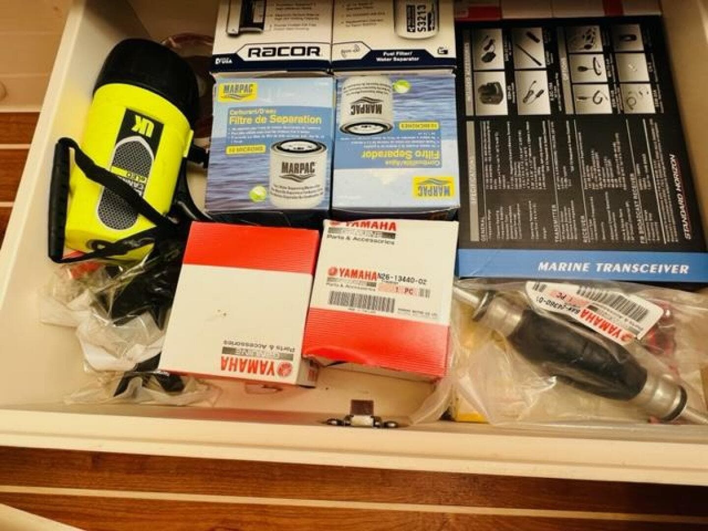 Drawer with marine equipment, Yamaha parts, filters, and a flashlight on a 2014 Grady-White Freedom 335.