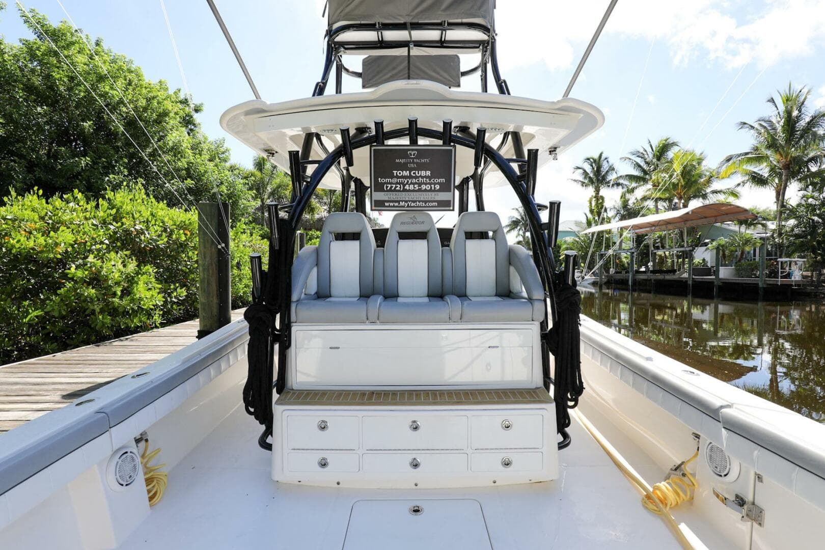 2020 Regulator 41 boat interior with seating and storage, docked by a lush, tropical canal.