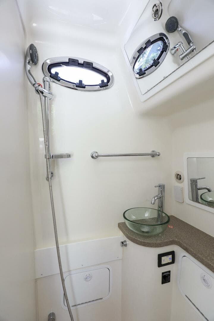 2020 Regulator 41 boat bathroom with shower, sink, and porthole windows.