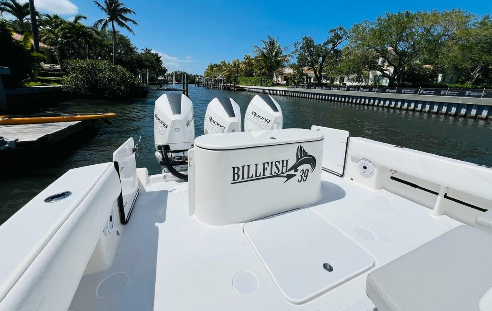 2015 Billfish 39 Custom CC boat with triple outboard engines docked in a scenic canal.