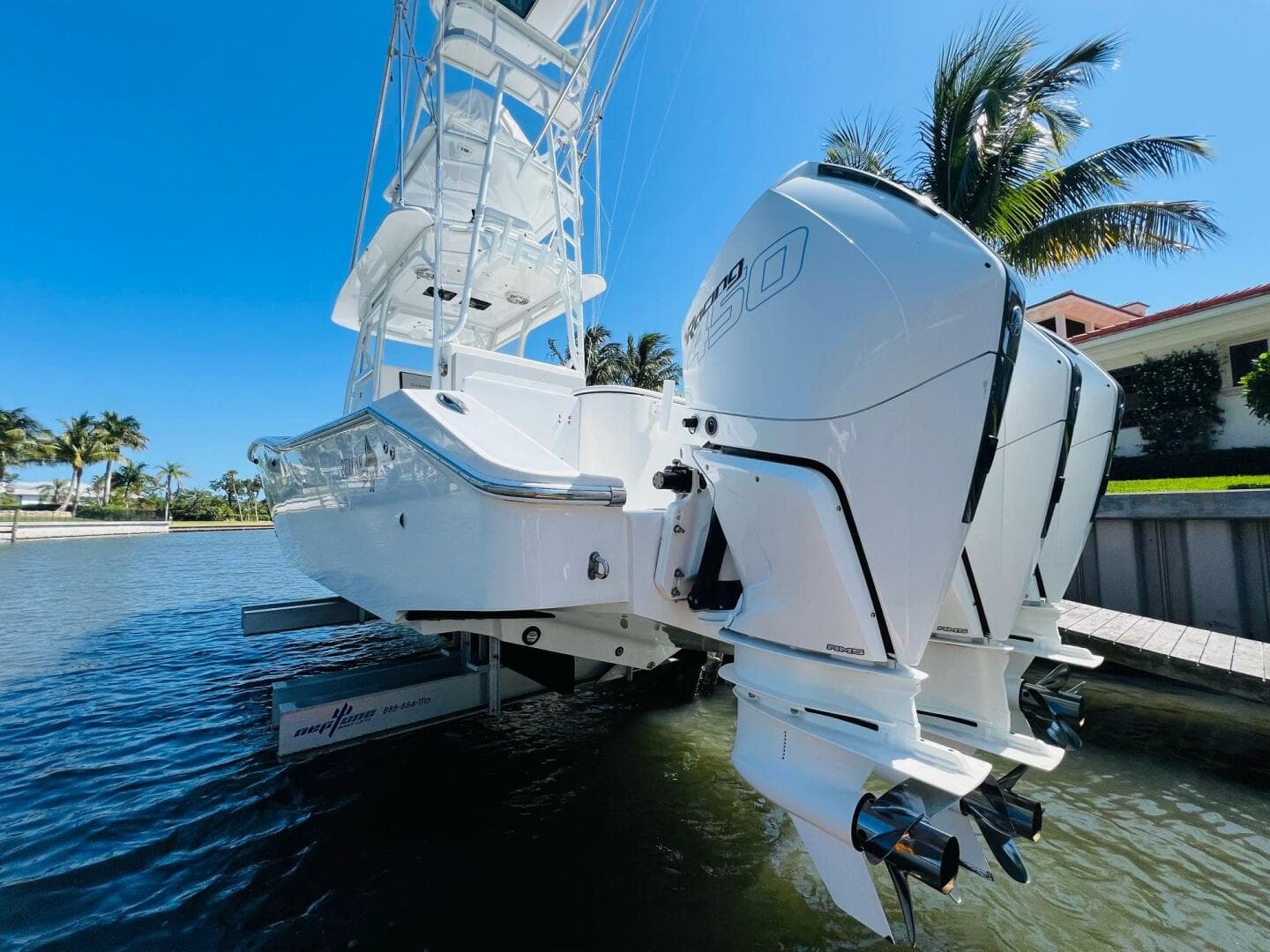 2015 Billfish 39 Custom CC boat with twin outboard engines docked by palm trees.