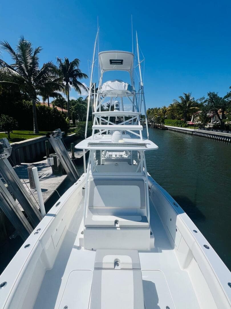 2015 Billfish 39 Custom CC boat docked by a canal on a sunny day.