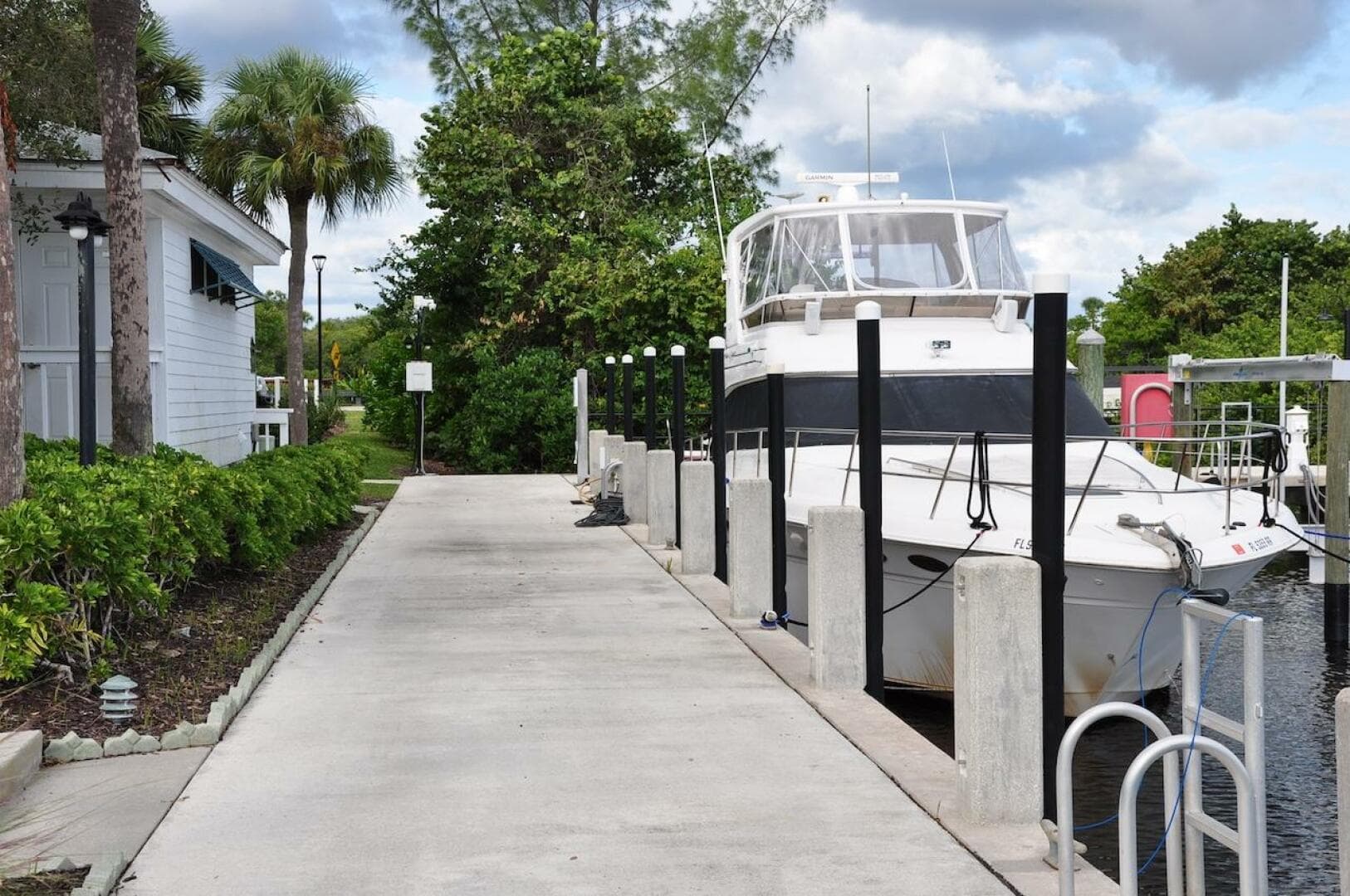 1998 Sea Ray 480 Sedan Bridge docked at a marina with lush greenery.