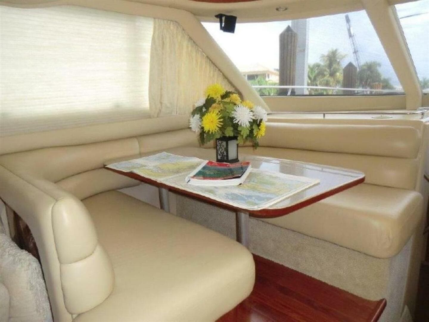 Interior of 1998 Sea Ray 480 Sedan Bridge with dining area and floral centerpiece.