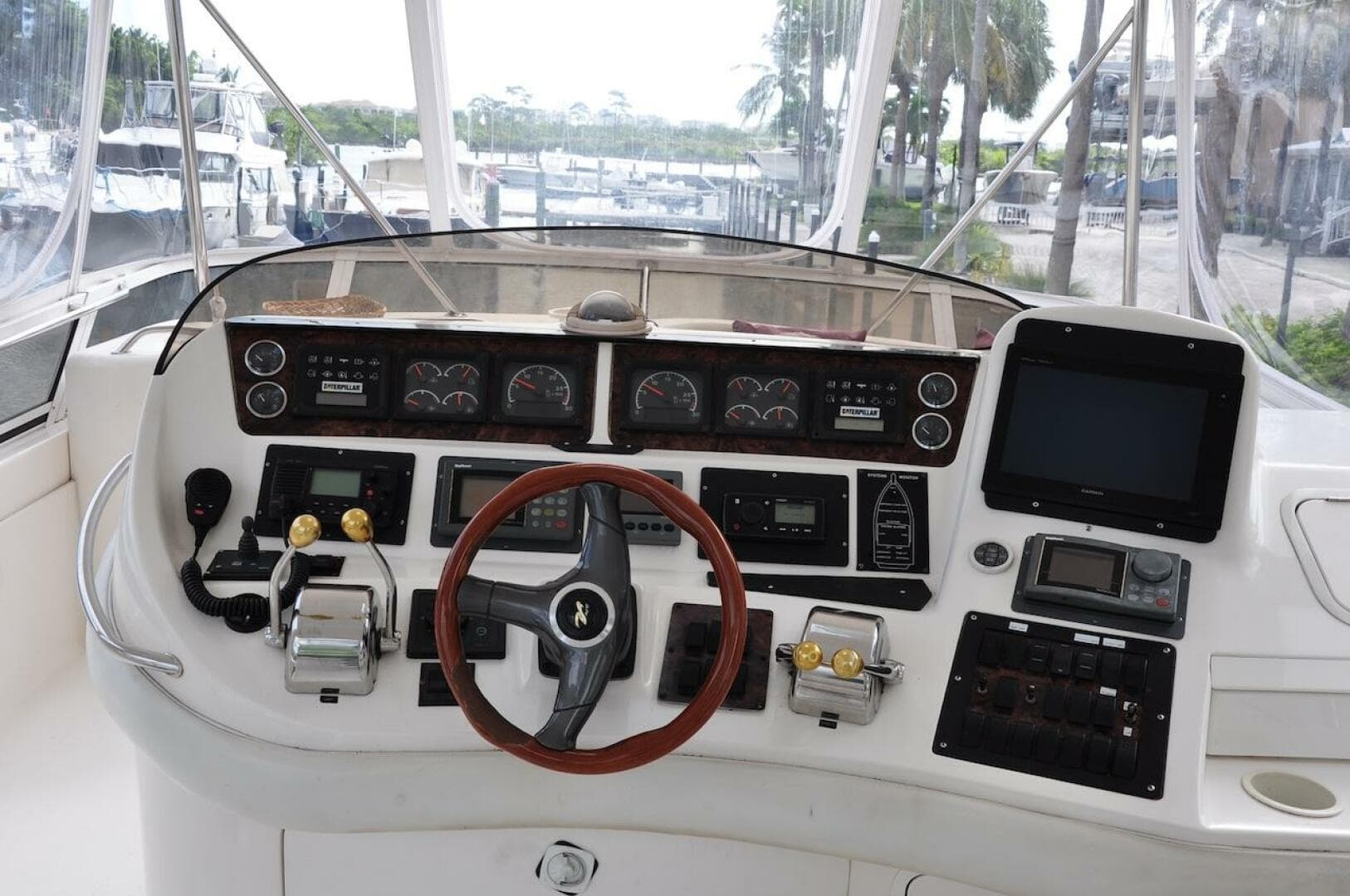 1998 Sea Ray 480 Sedan Bridge helm with steering wheel, controls, and navigation instruments.