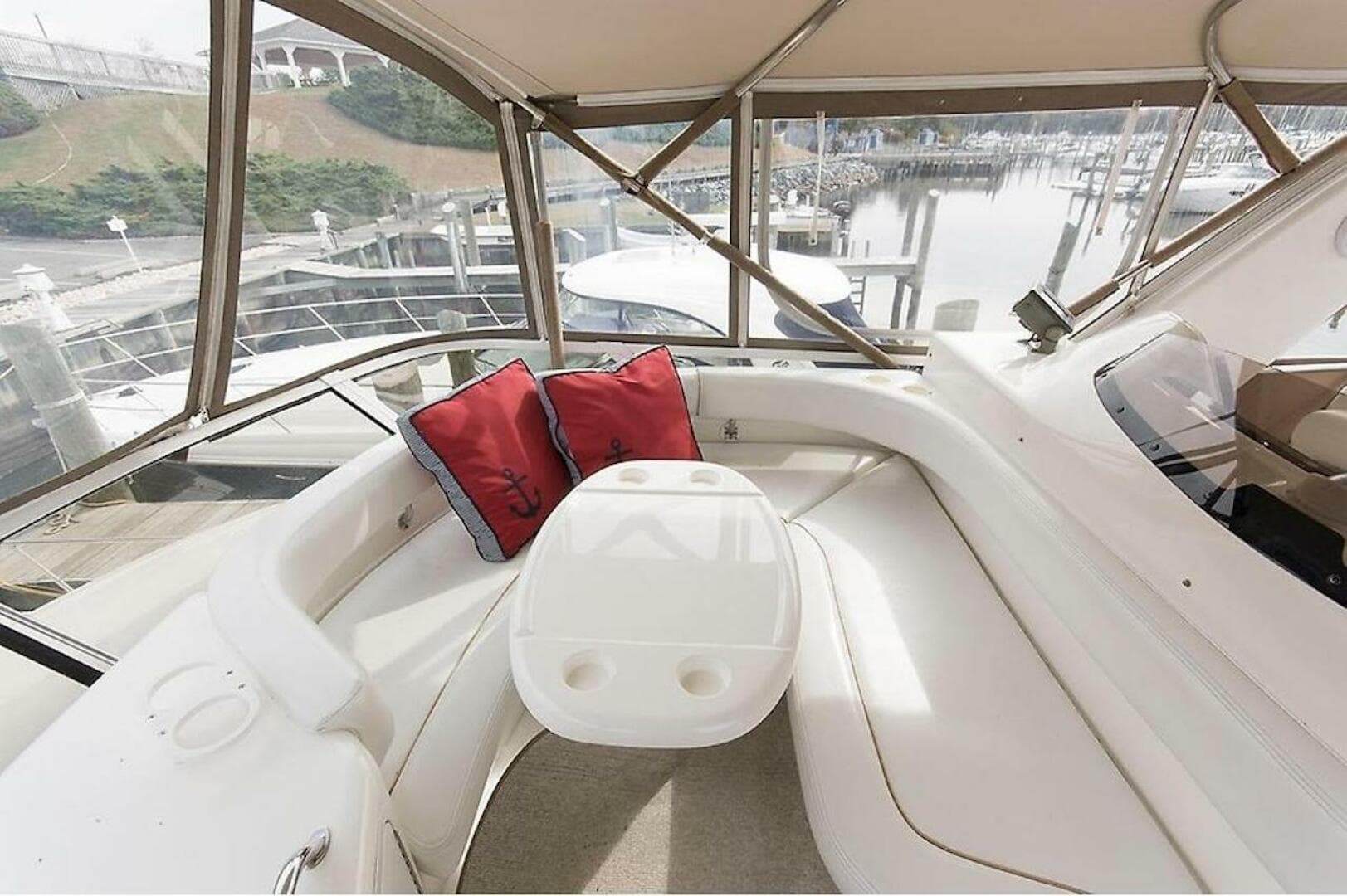 1998 Sea Ray 480 Sedan Bridge interior with white seating and red cushions.