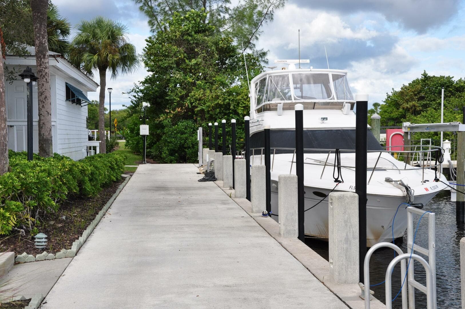 1998 Sea Ray 480 Sedan Bridge docked at a marina with lush greenery.