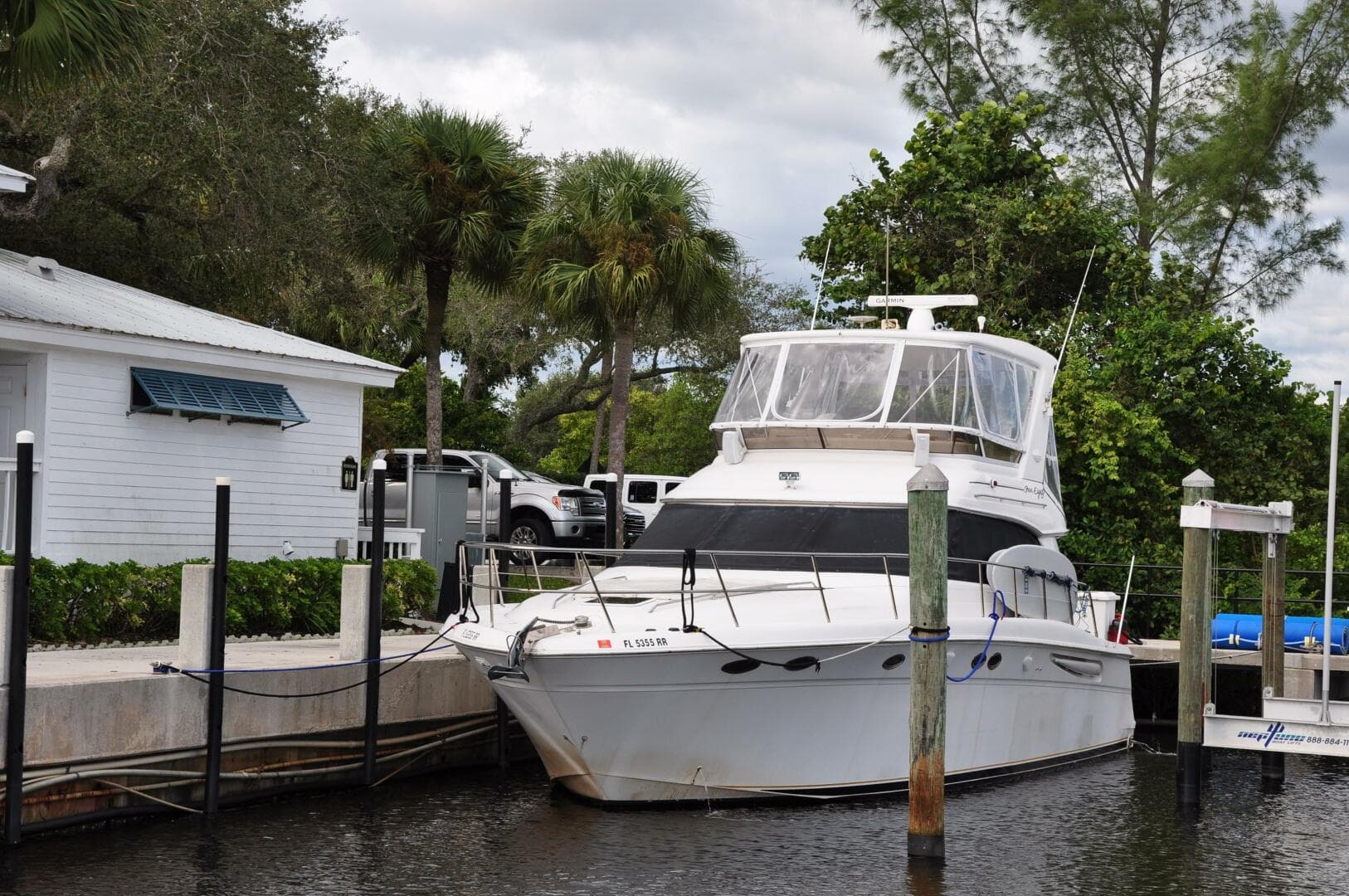 1998 Sea Ray 480 Sedan Bridge yacht docked near a white house.