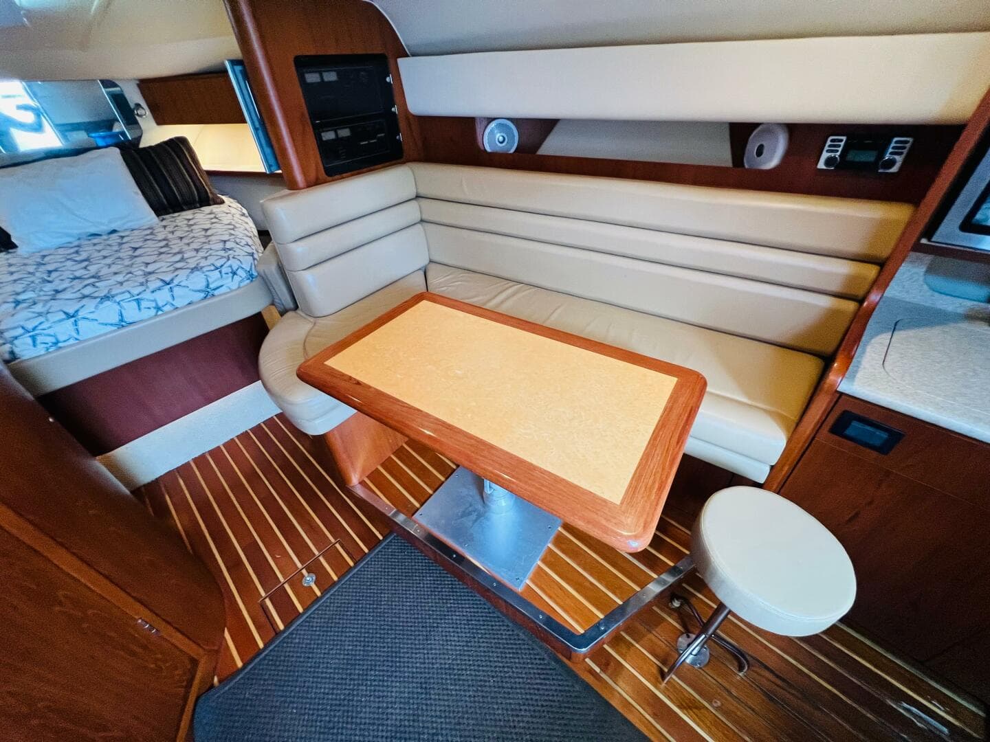 Interior of 2003 Tiara Yachts 3800 Open with seating and table, wooden flooring.